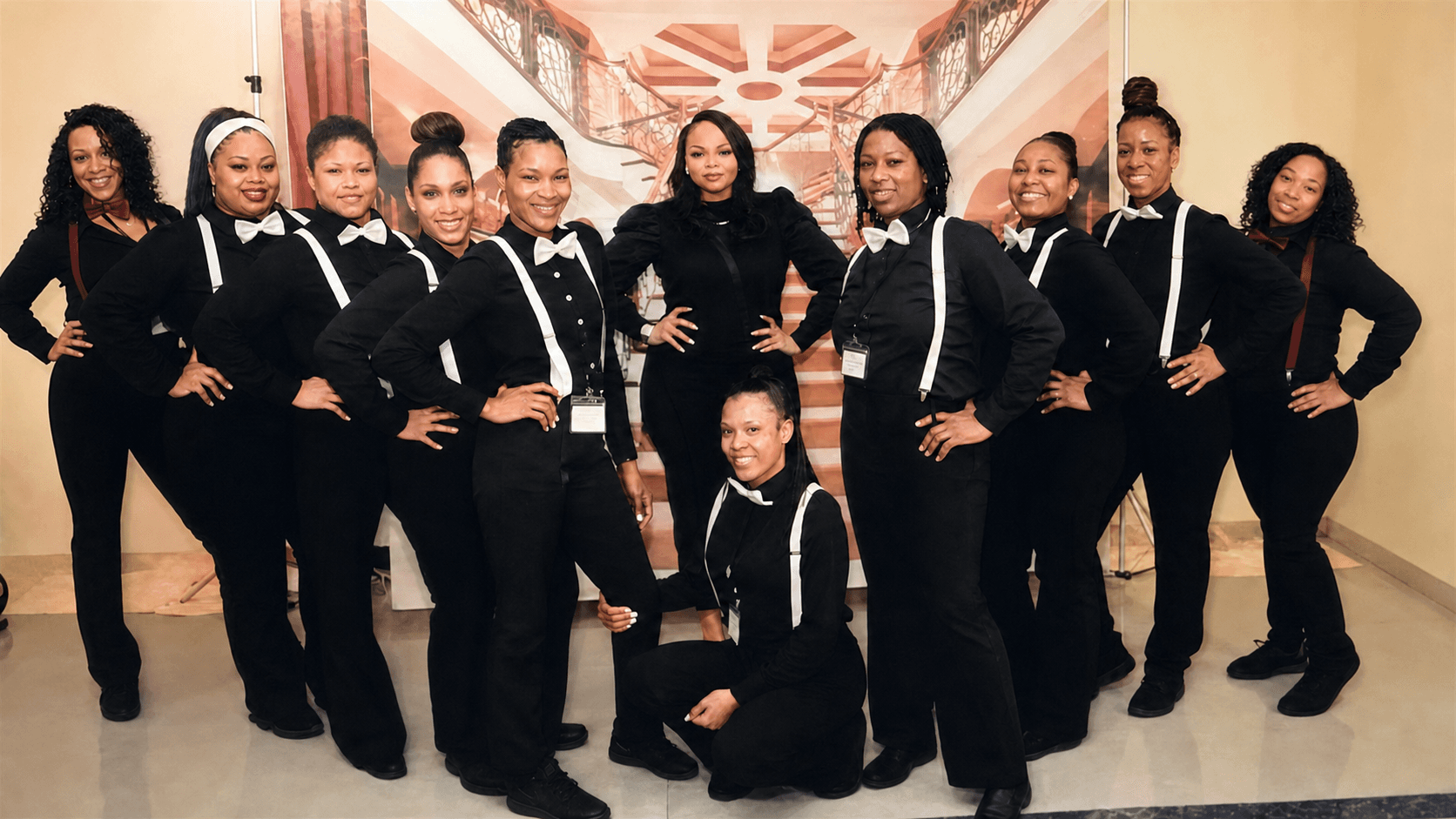 Specialist hospitality team gathered in formal black-and-white uniforms